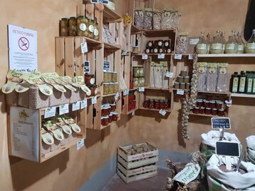 Gli scaffali dello spaccio con vasetti di sottoli, conserve e pacchi di pasta